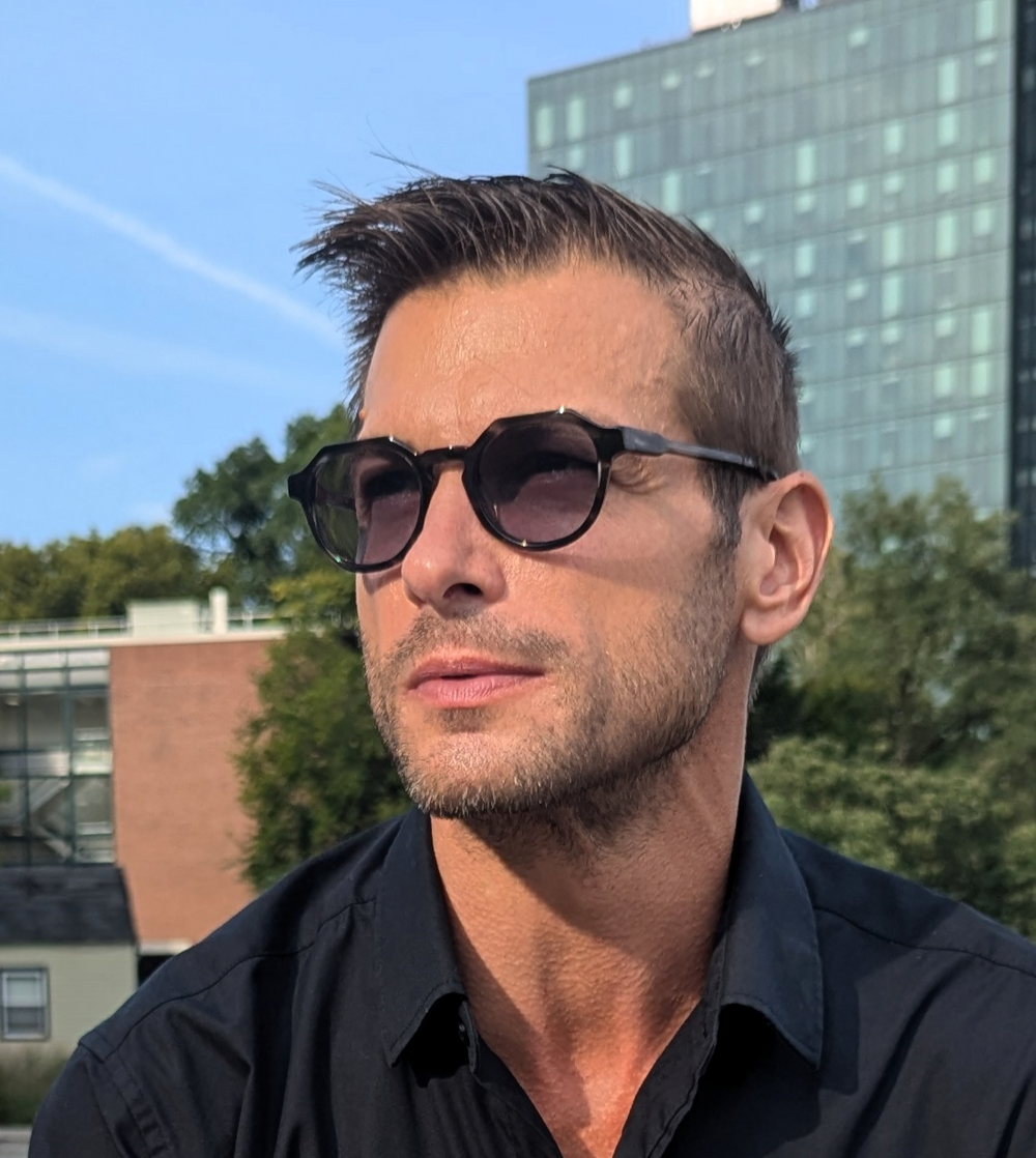 Man wearing sunglasses sitting on a bench Renee's Readers