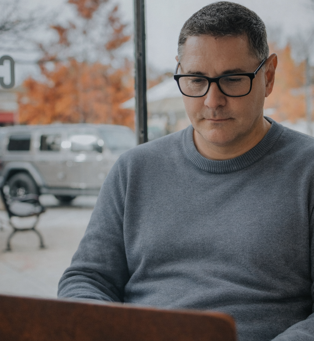 man wearing reading glasses looking at his laptop- Renee&