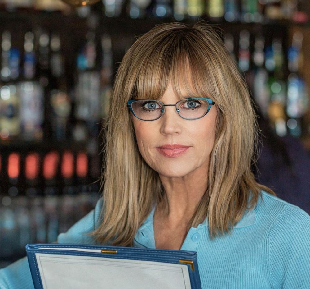 women wearing blue-framed reading glasses holding a menu -Renee's Readers