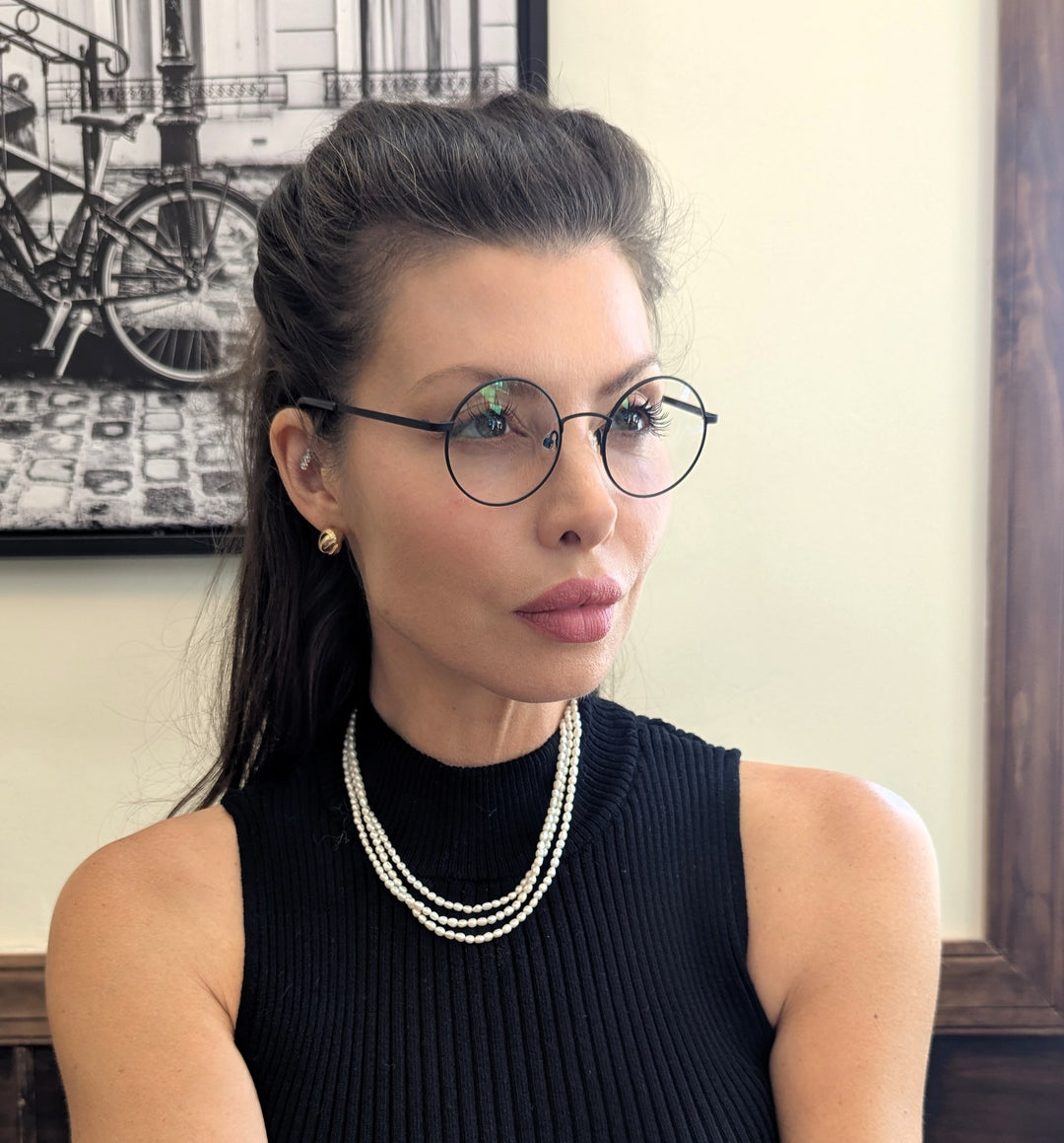 woman wearing round reading glasses looking at a computer | Renee's Readers